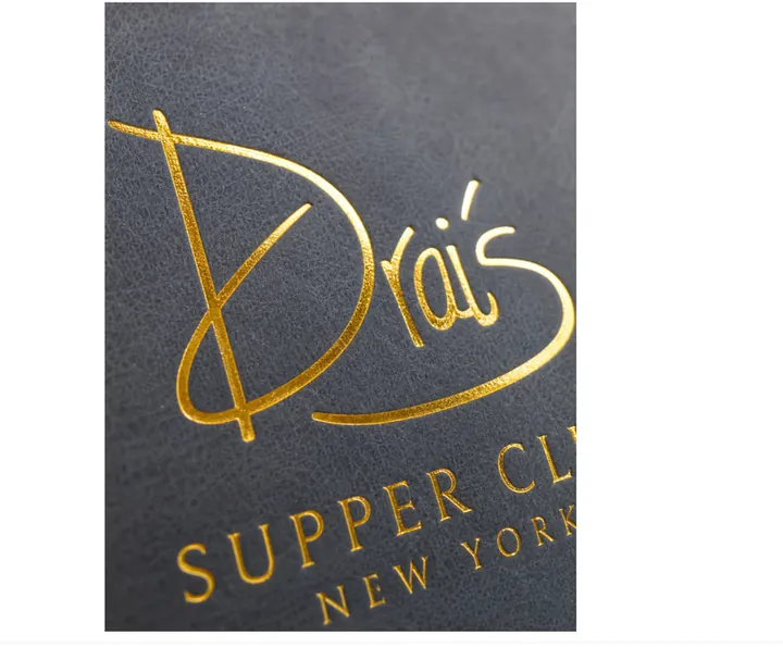 Gold foil hot stamping close-up on dark textured notebook cover